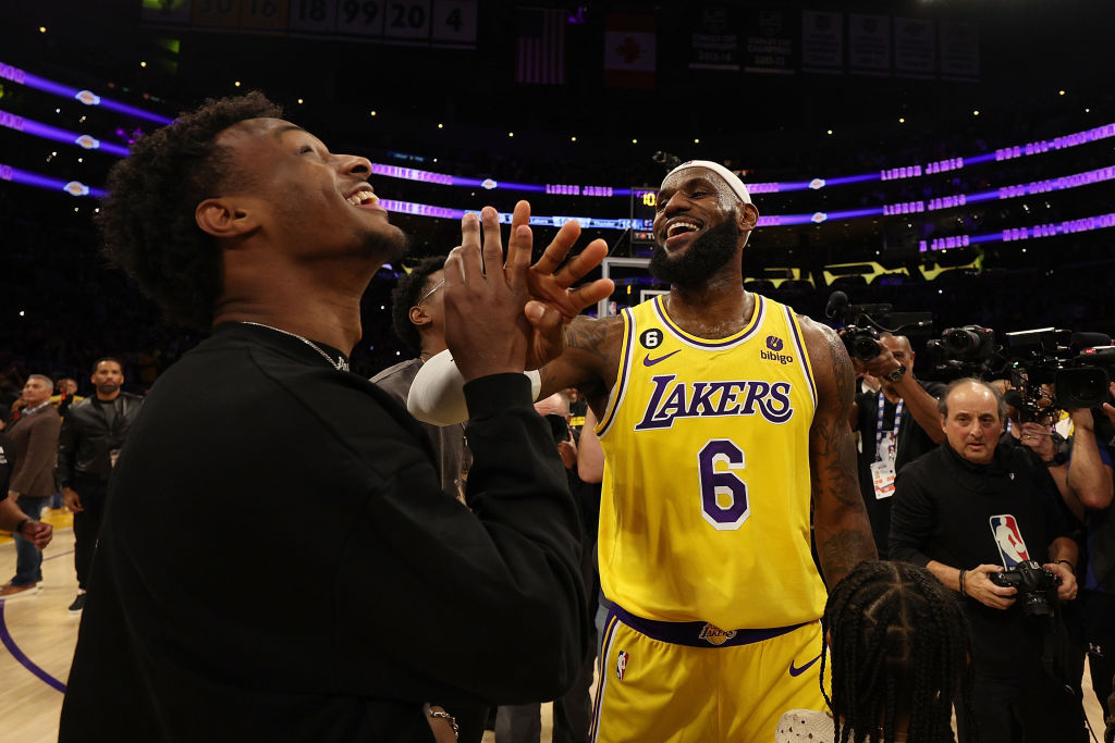 Bronny James with LeBron James during a Lakers game.